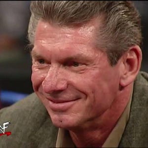 May include: A close-up of a smiling man with grey hair. He is wearing a brown shirt and a grey blazer. The WWF logo is visible on the left side of the blazer.