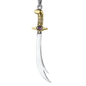 May include: A silver and gold pendant necklace featuring a stylized sword with a purple gemstone. The pendant is attached to a silver chain.
