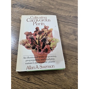 May include: A hardcover book titled Cultivating Carnivorous Plants by Allan A. Swenson. The white cover features a color illustration of a pitcher plant in a terracotta pot. The subtitle reads An illustrated guide to growing, propagating, and studying nature's most exotic plants.