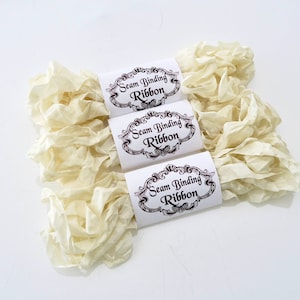 May include: Three spools of off-white seam binding ribbon with labels that read "Seam Binding Ribbon" in a decorative font.