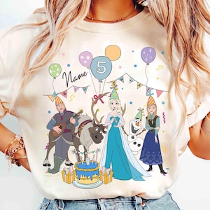 Może przedstawiać: Kremowa koszulka z kolorowym urodzinowym wzorem. Grafika zawiera postacie z kresk&oacute;wek, balony, tort i cyfrę 5. Słowo "Name" jest napisane nad wzorem, a pod nim słowo "Birthday".