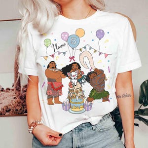 Puede incluir: Camiseta blanca con un gr&aacute;fico colorido de personajes de dibujos animados, una tarta de cumplea&ntilde;os, globos y el n&uacute;mero 5. La palabra "Name" est&aacute; escrita encima de los personajes.