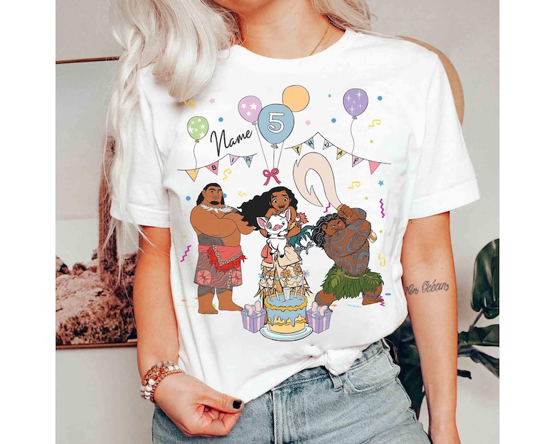 Puede incluir: Camiseta blanca con un gr&aacute;fico colorido de personajes de dibujos animados, una tarta de cumplea&ntilde;os, globos y el n&uacute;mero 5. La palabra "Name" est&aacute; escrita encima de los personajes.