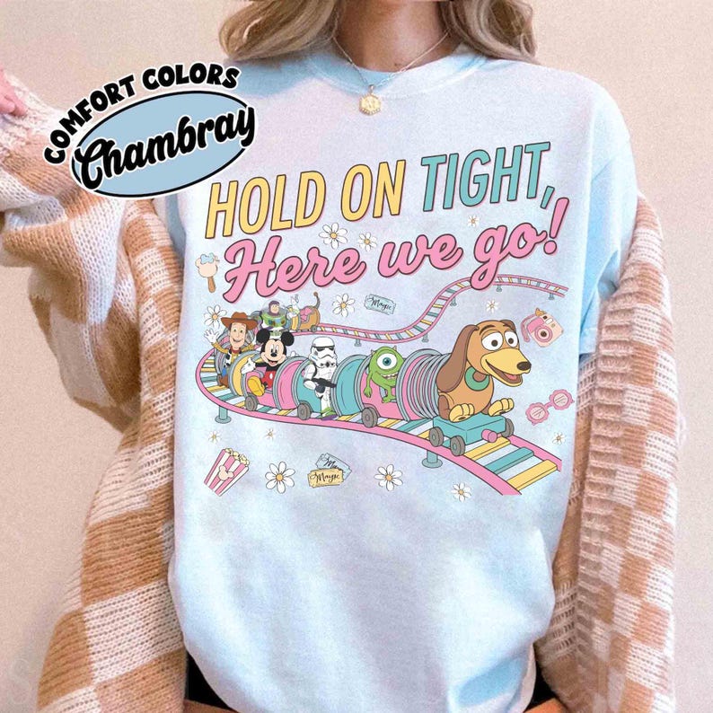 May include: A white ceramic mug with a black handle and the text "But First, Coffee" in a bold, black font. The mug is set against a blurred background, suggesting a cozy setting.