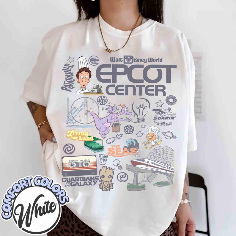 Peut inclure: T-shirt blanc Comfort Colors avec un motif graphique color&eacute;. Le motif comprend le texte "Walt Disney World EPCOT CENTER" et des ic&ocirc;nes et personnages comme Figment, un train et les Gardiens de la Galaxie.