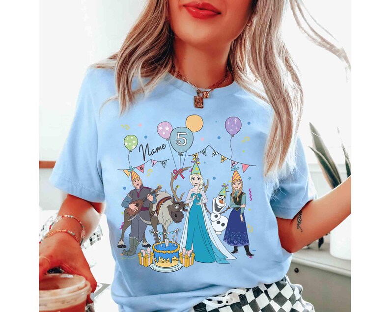 Może przedstawiać: Jasnoniebieska koszulka z motywem urodzinowym z postaciami z kresk&oacute;wek, balonami i tortem. Koszulka ma numer 5 i napis "Name". Projekt zawiera postacie z popularnego filmu animowanego.