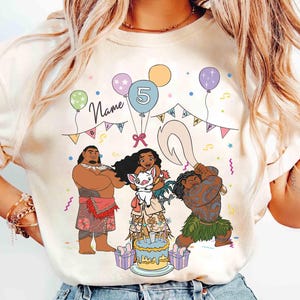 Puede incluir: Camiseta color crema con un gr&aacute;fico colorido de personajes de una popular pel&iacute;cula animada. El dise&ntilde;o incluye una tarta de cumplea&ntilde;os, globos y el n&uacute;mero 5. La palabra "Name" est&aacute; escrita encima del dise&ntilde;o.