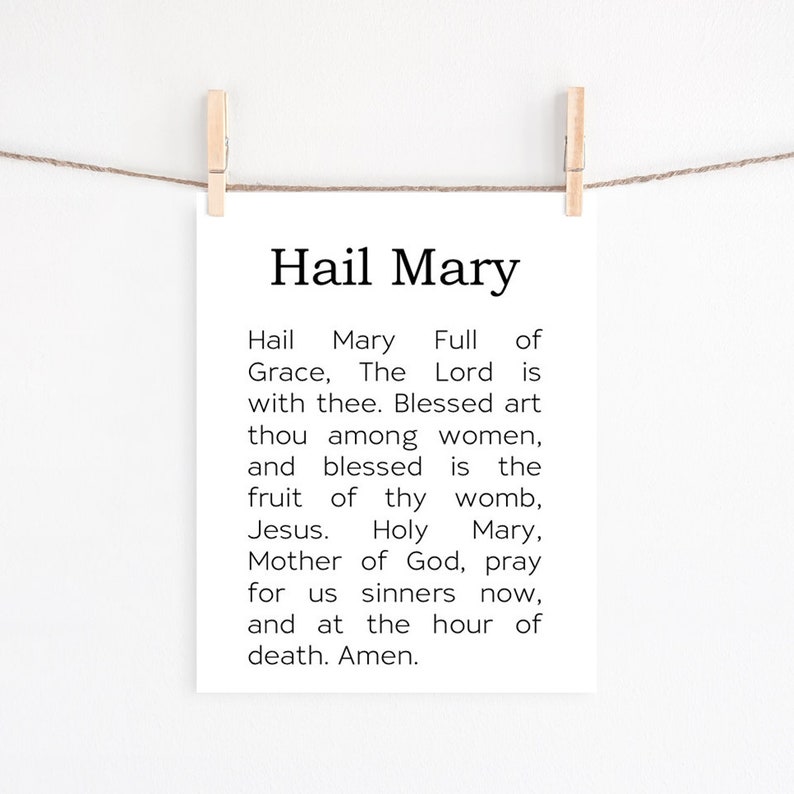 May include: A black and white printable wall art print with the text "Hail Mary" and the Hail Mary prayer.