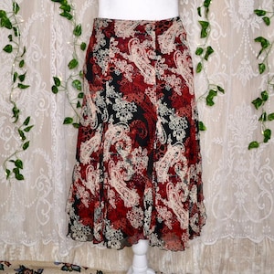 Könnte beinhalten: Ein roter, schwarzer und weißer Rock mit Paisley-Muster und einem Rüschen-Saum.