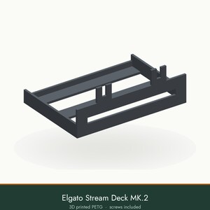 May include: A dark gray 3D printed PETG mounting bracket for an Elgato Stream Deck MK.2. The rectangular frame features a flat base, raised side walls, and two vertical support tabs extending from the front edge to secure the device.
