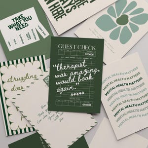 May include: A collection of greeting cards and stationery in shades of green and white. The cards feature various designs and text, including phrases like "Take What You Need" and "Mental Health Matters."