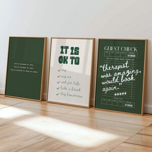 May include: Three framed art prints with inspirational quotes. One is dark green with white text, another has the words "IT IS OK TO" and a list, and the third is a green "Guest Check" with a quote.