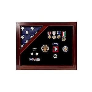 May include: A wooden shadow box with a folded American flag, military medals, and patches. The shadow box has a black velvet background.