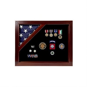 May include: A wooden shadow box with a folded American flag, military medals, and patches. The shadow box has a black velvet background.