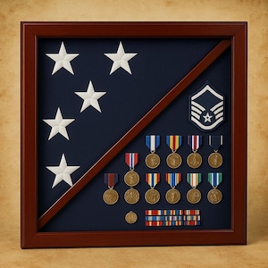May include: A wooden framed display case with a dark blue background. The case features white stars, medals with colored ribbons, and a military insignia. The frame is a dark brown color.
