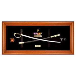 May include: A wooden framed display case with a black background, showcasing a crossed pair of military swords with a gold and silver hilt. A small group of medals are displayed above the swords.