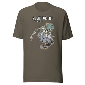 Peut inclure: Un t-shirt vert avec un squelette faisant du skateboard et le texte "Skate for life even after..." imprimé sur le devant.