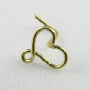 Pu&ograve; includere: Un anello per il naso a forma di cuore in oro, fatto di filo.