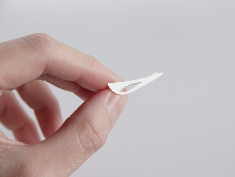 May include: A white adhesive bandage with a small, clear, plastic strip in the center.