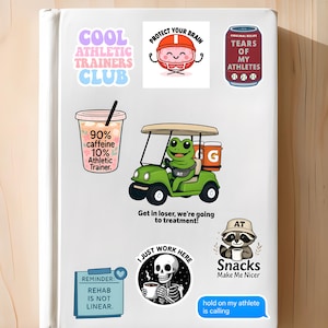 May include: A collection of colorful stickers with various designs and text. The stickers include phrases like "Cool Athletic Trainers Club," "Protect Your Brain," and "Tears of My Athletes." Other stickers feature a frog in a golf cart and a raccoon with a coffee cup.