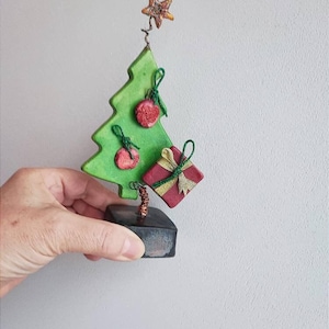 Green chistmas tree sculpture, xmas fir tree with red balls and sparkling star on top, ceramic christmas tree miniature on brown base