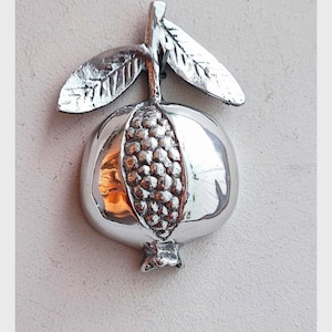 Silver pomegranate sculpture with seeds, aluminum pomegranate on leafy twig, half pomegranate silver sculpture