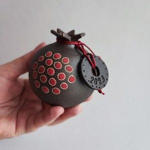 Dark pomegranate, lucky pomegranate in dark brown with new year 2023 charm, life size pomegranate with red seeds