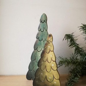 Peut inclure: Deux sapins de Noël en bois, l'un vert et l'autre jaune, sur un fond blanc.