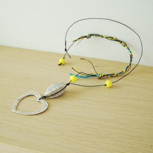 Metal heart necklace, long boho necklace of silver plated, alloy heart on black cord with colourful, braided side and yellow, glass beads,