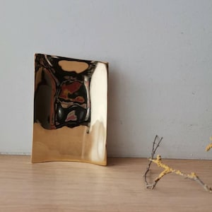 Brass plate card holder, rectangular brass plate with gleaming polished surface, modern minimalist desk organiser for cards, paperclips, etc