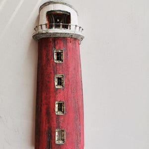 Czerwona rzeźba latarni morskiej, kamionkowa latarnia morska wisząca na ścianie w kolorze czerwonym z kopulastym dachem i oknami, ręcznie wykonana przez Greków, ceramiczna latarnia morska