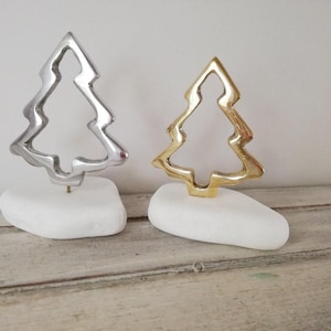 Christmas trees set, outline of brass and aluminum tree sculptures on white stones, metal christmas trees, minimalist xmas trees, set of two