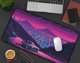 May include: A large rectangular mousepad featuring a vibrant, stylized cityscape with a purple car driving on a winding road. The design includes a mountain range and a city skyline in shades of purple, pink, and blue. A white computer mouse sits on the pad.
