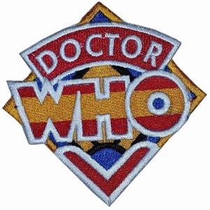 May include: An embroidered patch featuring the text DOCTOR WHO in white lettering with a light blue border. The design includes a red arched banner above the text and a diamond-shaped background with gold, red, and blue geometric patterns.