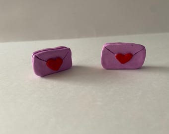 May include: Two small purple clay envelopes with a red heart on the front.