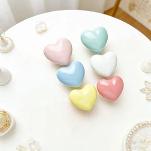 May include: A set of three ceramic nesting bowls in shades of blue, green, and white. The bowls feature a speckled glaze and a simple, modern design. The largest bowl is approximately 6 inches in diameter.