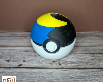 May include: A 3D printed Pokeball with a black, blue, and yellow design. The Pokeball is a popular collectible from the Pokemon franchise.