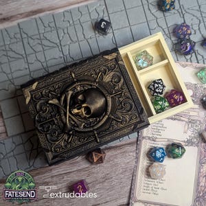 May include: A black and gold decorative box with a skull and crossbones design. The box has a hinged lid and opens to reveal a compartment for dice. The box is made of resin and is a great way to store and display dice.