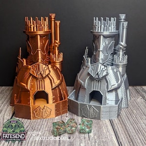 May include: Two 3D printed dice towers, one copper and one silver, with a decorative design. The towers are on a wooden surface with three green dice.