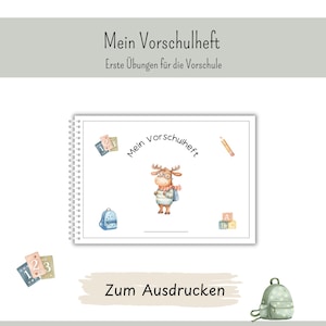 May include: A spiral-bound workbook titled Mein Vorschulheft, Erste Übungen für die Vorschule. The cover features a cartoon moose wearing glasses and a scarf, surrounded by illustrations of a backpack, alphabet blocks, and number cards.
