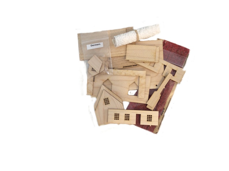 Peut inclure: Un ensemble de pi&egrave;ces en bois pour la construction d'une maison miniature, comprenant des murs, des &eacute;l&eacute;ments de toit et des fen&ecirc;tres. Les pi&egrave;ces sont dans un sac &eacute;tiquet&eacute; "Dormers".