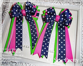 May include: Three navy blue and white polka dot hair bows with pink and green ribbon tails. The bows are arranged in a row on a white surface. The text "O' Sew Pretty" is visible in the bottom right corner of the image.  Sold as a single or a pair in short or standard tails on a barrette or elastic ponytail holder.