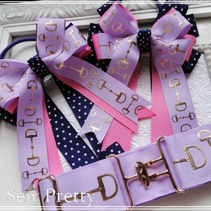 May include: Three purple and pink hair bows with gold equestrian stirrup accents and a purple fabric belt with a gold buckle and stirrup accents. The text "O' Sew Pretty" is visible in the bottom left corner of the image.