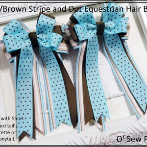 May include: Two blue and brown equestrian hair bows with blue polka dots and brown stripes. The bows are available with short or standard tails and can be attached to a barrette or elastic ponytail. "O' Sew Pretty" is written in the bottom right corner of the image.
