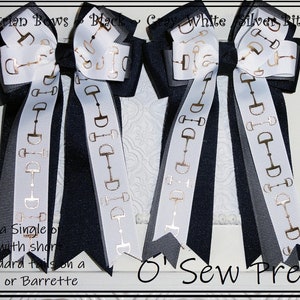 May include: Two black, gray, and white equestrian bows with gold horse bit accents. The bows are sold as a single or a pair, with short or standard tails, and can be attached to a ponytail or barrette. "O Sew Pretty" is written on the bottom of the image.