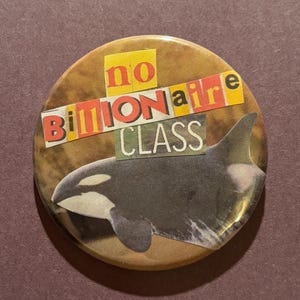 May include: Round button with a brown background and the text "no Billionaire CLASS" in a collage style. A black and white orca whale illustration is featured on the button.