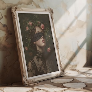May include: A framed portrait of a woman wearing a black blindfold, with a floral crown of pink roses and green leaves. The artwork is in an ornate, cream-coloured frame, leaning against a textured wall.