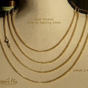 May include: Four gold vermeil wheat chains on a mannequin, with the text "Gold Vermeil Gold on Sterling Silver" and "Wheat 2.4mm".