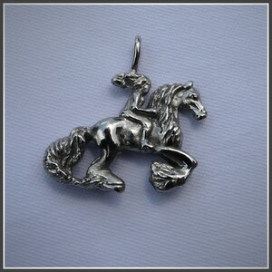Peut inclure: Un pendentif en argent repr&eacute;sentant une femme &agrave; cheval. Le pendentif est d&eacute;taill&eacute; et pr&eacute;sente une finition textur&eacute;e.