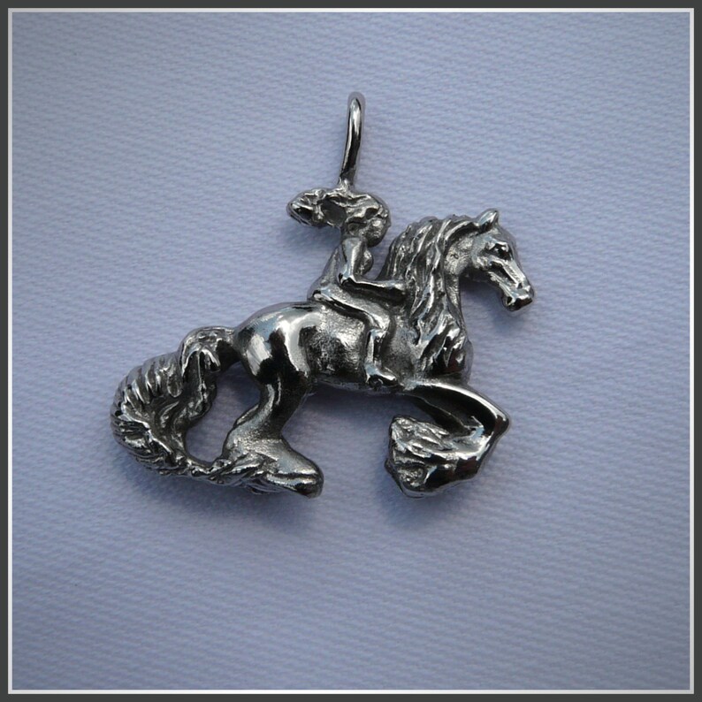 Peut inclure: Un pendentif en argent repr&eacute;sentant une femme &agrave; cheval. Le pendentif est d&eacute;taill&eacute; et pr&eacute;sente une finition textur&eacute;e.